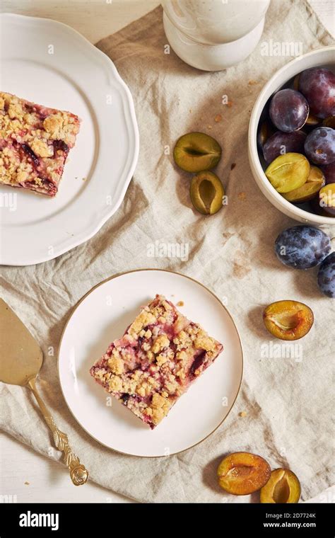 Homemade Plum Cake With Crumbles On Plates On A White Table Stock Photo