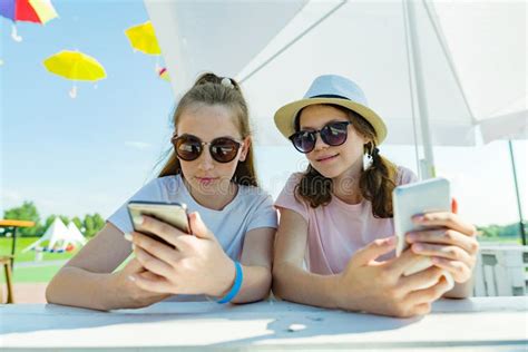 Unga Tonåriga Flickor Med Mobiltelefoner Sitt I Ett Gatakafé En Solig