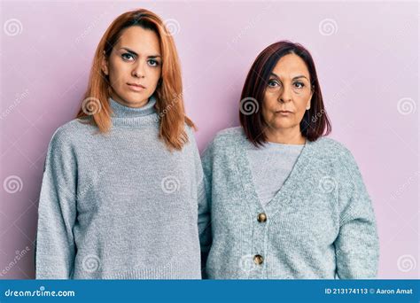 Latin Mother And Daughter Wearing Casual Clothes Relaxed With Serious Expression On Face Stock