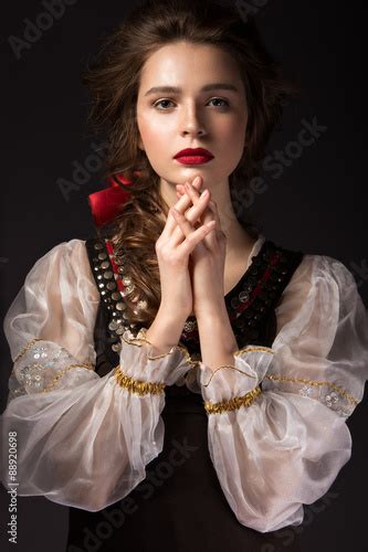beautiful russian girl in national dress with a braid hairstyle and red lips beauty face