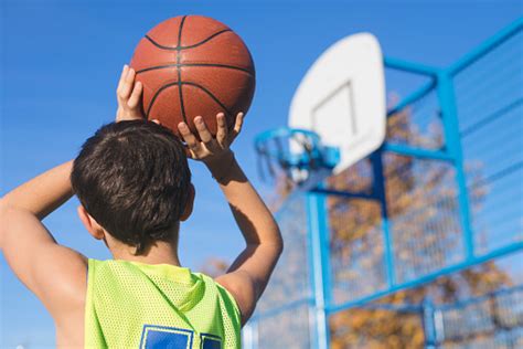 Teenager Throwing A Basketball Into The Hoop Stock Photo Download