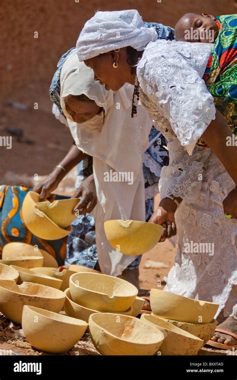 Two Fulani Women Inspect The Calabashes For Sale In The Weekly Market