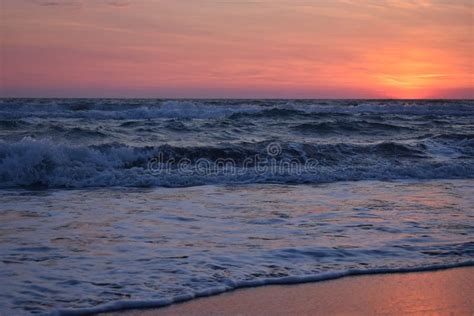 A Beautiful Sunset On The Beach In The Turbulent Ocean Stock Photo