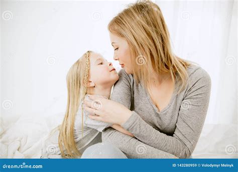 Young Mother And Her Little Daughter Hugging And Kissing On Bed Stock Image Image Of