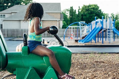 Young Black Girl Riding On A Cricket At A Playground By Stocksy