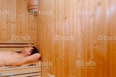 Handsome Middle Aged Man Lying In Electric Sauna Heater In Steam Room Relaxation And Rest