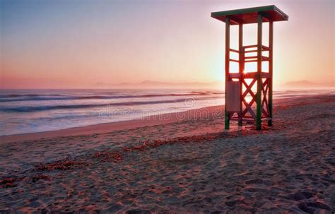 Lifeguard Tower Sunrise Footprints On Secluded Beach With Mountains