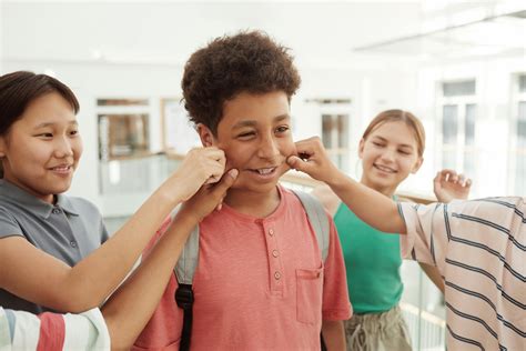 Children Pinching A Young Boys Cheeks · Free Stock Photo