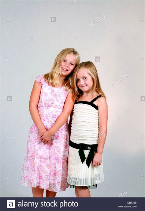 Two Pretty Blonde Preteen Girls In Dresses Smiling Stock