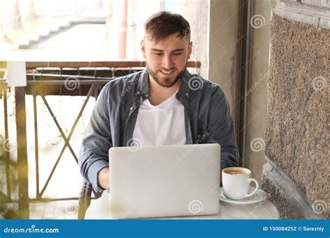 Young Freelancer With Laptop Working In Cafe Stock Photo Image Of