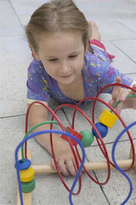 Little Girl Playing With Coloured Wooden Toy Stock Photo