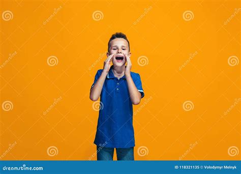 Isolated On Orange Young Casual Teen Boy Shouting At Studio Stock Image