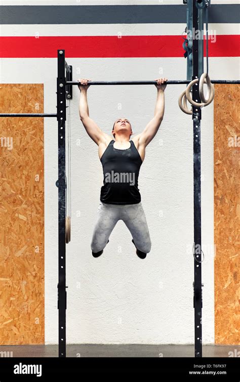 Young Fit Strong Muscular Girl Athlete Doing Pull Ups On A Bar During