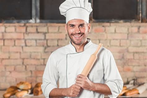 Free Photo Smiling Male Baker Holding Rolling Pin In The Bakery