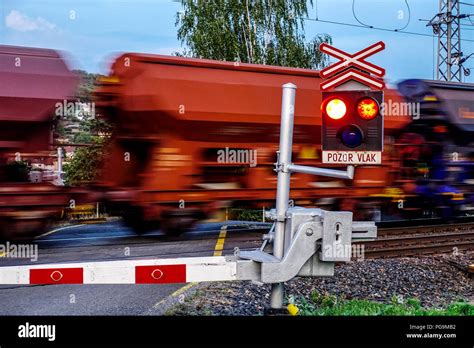 Cargo Train Passing A Railroad Crossing With Red Traffic Lights