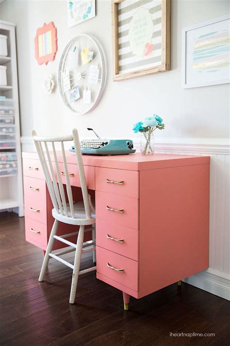 A Pink Desk And Chair In A Room With Pictures On The Wall Behind It