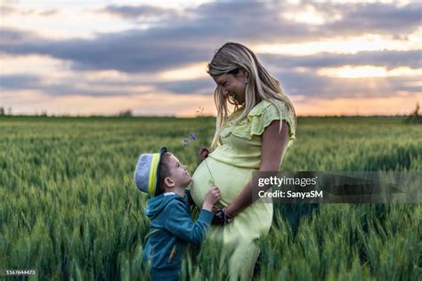 Pregnant Mother And Her Son Sharing Love In Nature On A Sunset High Res
