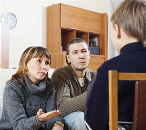 Parents Talking To Teenager In Living Room Unhappy Marriage