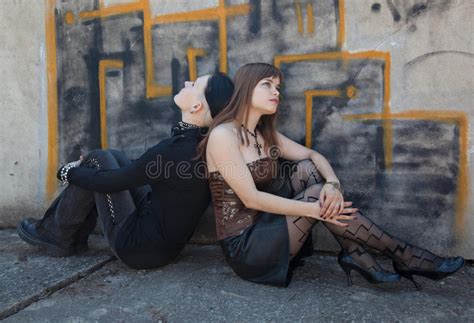 Two Girls Sitting In Front Of Graffiti Wall Stock Image
