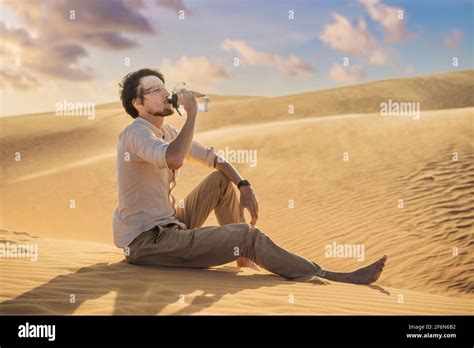 Man Feels Thirst And Drinks Water In The Desert Stock Photo Alamy