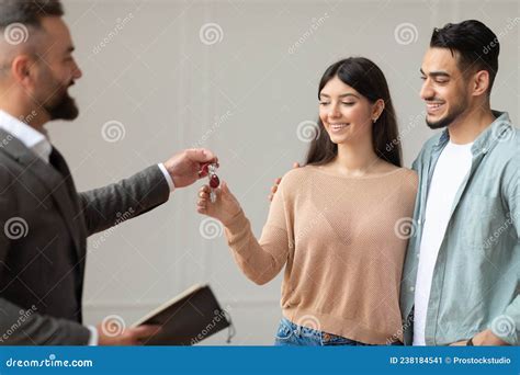 Real Estate Agent Giving Keys To Happy Arab Buyers Stock Image - Image