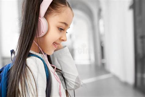 Pretty Brunette School Girl Wearing Big Pink Headphones Stock Image