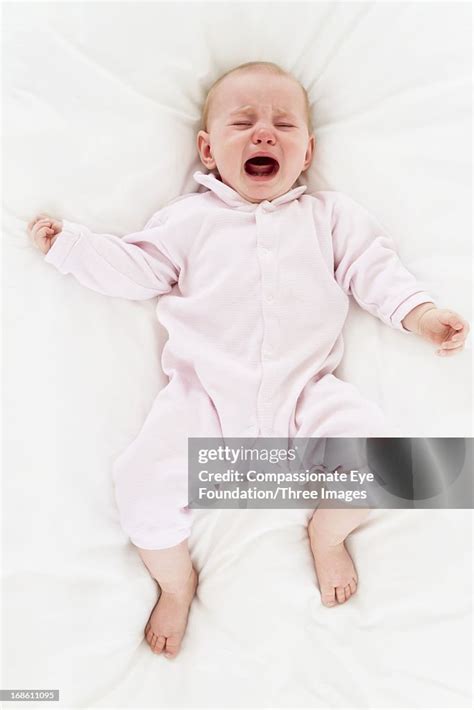 Crying Baby Laying On Bed High Res Stock Photo Getty Images