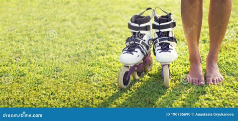 Female Legs Barefoot Standing On The Green Grass Next To The White