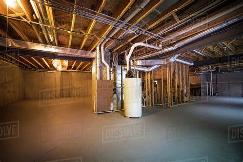 How to design a finished basement. Empty basement with pipes on ceiling - Stock Photo - Dissolve