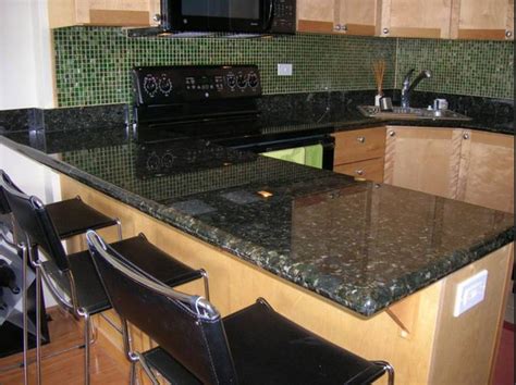 Dark gray cabinets and white spring granite countertops matched very well. Black Granite Countertops With Tile Backsplash- Kitchen Design- The World