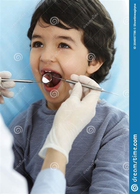 Little Arab Boy Sitting At Dental Chair With Open Mouth During Oral