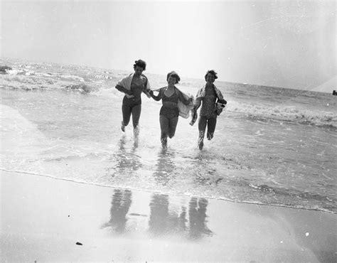 Three Girls Running In The Sea At Bournemouth Beach In Dorset British