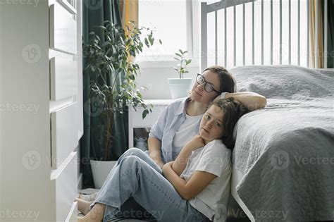 Mother And Daughter Sitting On Floor At Cozy Home Woman And Pre Teen Girl Spending Time