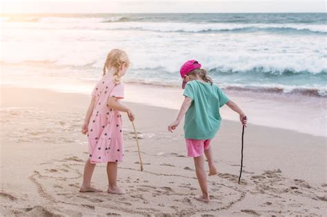 premium photo two cheerful girls play merrily on the seashore friendship concept