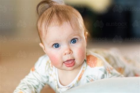 Image Of Happy Blue Eyed Baby Close Up Playing On Floor Austockphoto