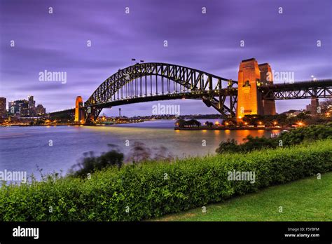 Side View Of Famous Sydney Harbour Bridge At Sunset With Illumination