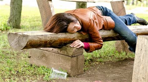 Drunk Woman Sleeping It Off On A Wooden Bench In A Park Lying Face Down In Her Leather Jacket
