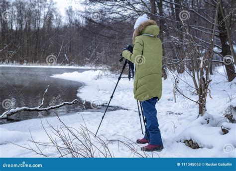Woman Amateur Photographer Takes A Winter Landscape On The Lake In The Forest Copy Space Stock