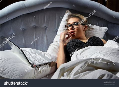 Portrait Of Woman Lying On Bed With A Laptop And Play With Herself