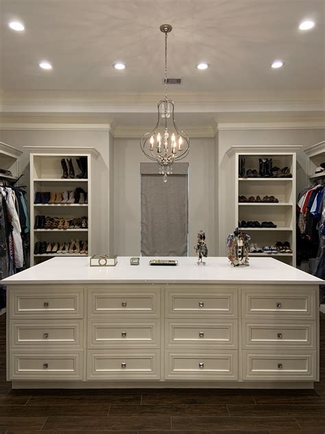 Island With Drawers In The Walk In Master Closet With Chandelier And