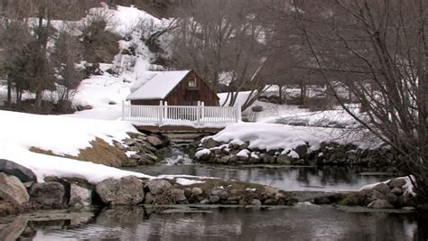Winter Scene With Wood Cabin At Top Of Small Pond And