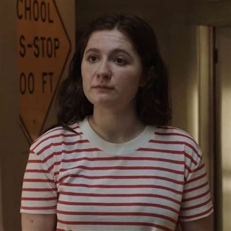 A Woman In A Red And White Striped Shirt Is Looking At The Camera While Standing Next To A
