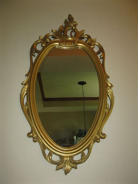 An Ornate Gold Mirror Hanging On The Wall
