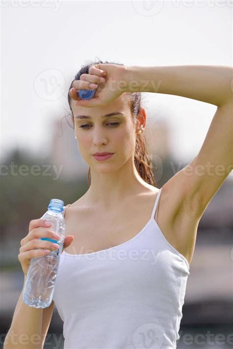 Young Beautiful Woman Drinking Water After Fitness Exercise 10405209