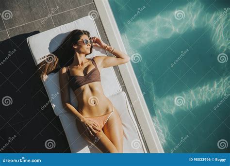 Junge Frau Die Durch Das Pool Auf Sunbed Liegt Stockfoto Bild Von Schön Badebekleidung 98033996