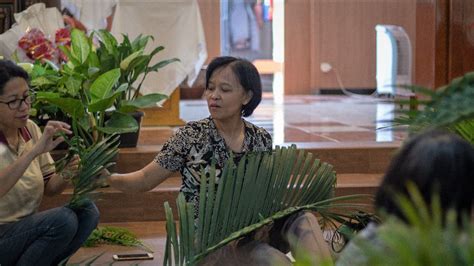 Pastor memercik daun palma yang dibawa oleh umat katolik saat mengikuti misa minggu palma di gereja santo gregorius agung. Santa Bernadet