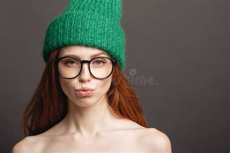 Ginger Woman Wearing Glasses And Green Hat Pouting Her Lips Ready For
