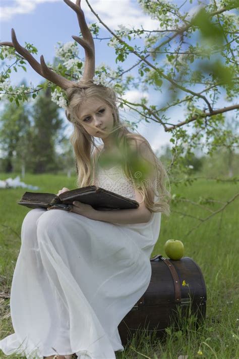 Teen Beautiful Blonde Girl Wearing White Dress With Deer Horns O Stock