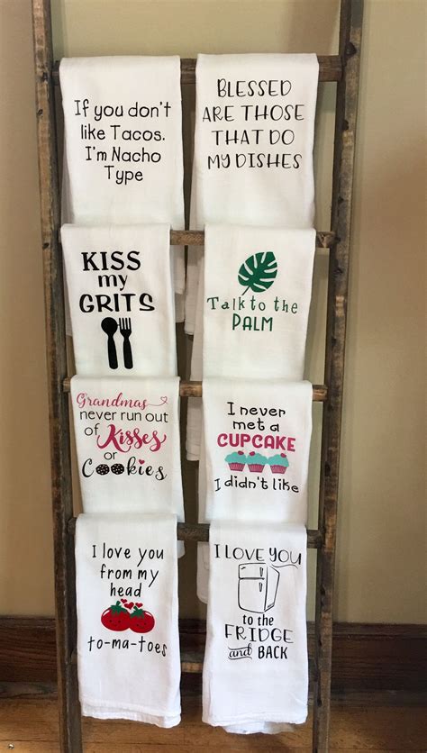 Four Tea Towels Are Hanging On A Wooden Rack In Front Of A Wall With