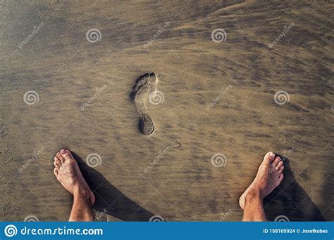 Human Footprint With Barefoot Feet In Brown Yellow Sand Beach